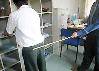 Senior schoolboy being caned in school office