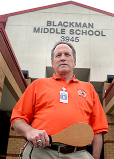 Middle School principal holding paddle